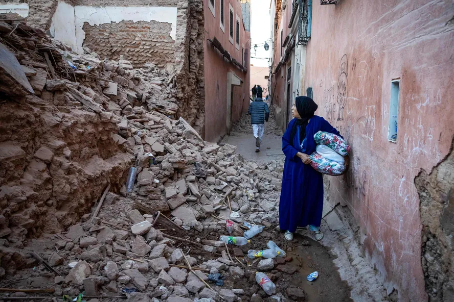 Uma mulher olha para os escombros de um edifício na cidade velha de Marrakech, no Marrocos